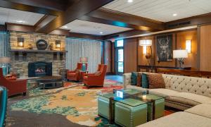 a living room with a couch and a fireplace at Holiday Inn Stevens Point - Convention Center by IHG in Stevens Point