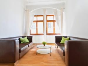 a living room with two leather couches and a table at The Square Coburg in Coburg