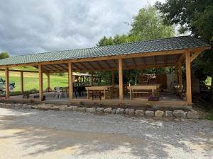 a wooden pavilion with tables and chairs in a field at Cabanele din RÂTUL FLORILOR in Hotar