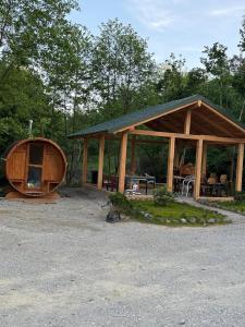 a large wooden cabin with a boat next to it at Cabanele din RÂTUL FLORILOR in Hotar