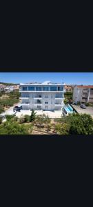 a large white apartment building with a parking lot at Apartments Soho in Trogir