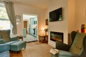 a living room with a fireplace and a tv at Finest Retreats - 2 Haywood View in Grindleford Bridge