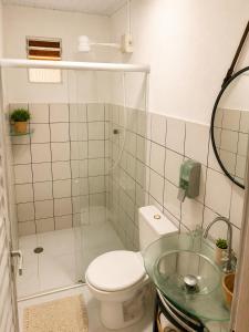 a bathroom with a toilet and a glass sink at Pousada da Gih in Fernando de Noronha