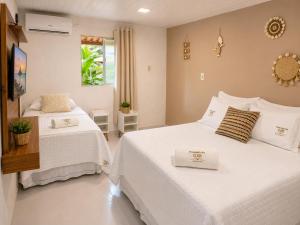 a bedroom with two beds and a window at Pousada da Gih in Fernando de Noronha