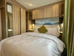 a bedroom with a large white bed in it at Craig Tara Holiday Park 101 Bay View in Ayr