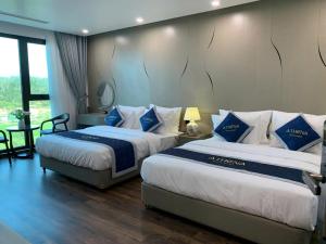a hotel room with two beds with blue and white pillows at Athena Coto Hotel in Nam Cap +20 photos