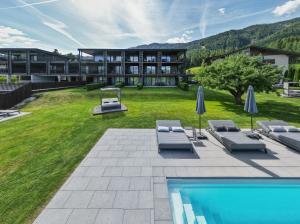 a resort with a swimming pool and a building at B&B - Rooms&Apartments Oberwiesen in Brunico
