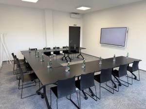a conference room with a table and chairs and a screen at WE Hotel EXPO Prague in Prague