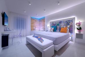 a white bedroom with a large bed and a couch at Amalfi Suite Boutique Hotel in Amalfi