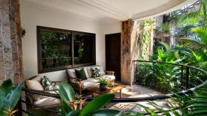 a porch with a couch and chairs on a balcony at Luxor Gardens Residences in Accra