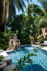 a swimming pool with palm trees in a yard at Luxor Gardens Residences in Accra +21 photos