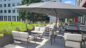 a row of chairs and an umbrella on a patio at WE Hotel EXPO Prague in Prague