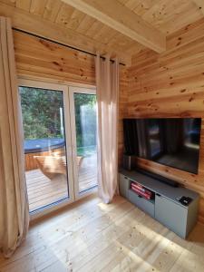 a living room with a flat screen tv in a log cabin at Sarenka na Roztoczu in Nielisz