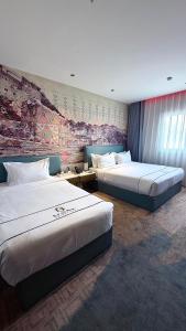 a hotel room with two beds and a mural at Golden New Hotel in Abha