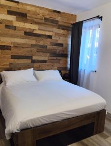a bed in a room with a wooden wall at B&b la bessolina in Ivrea