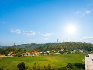 a green field with the sun in the sky at Athena Coto Hotel in Nam Cap