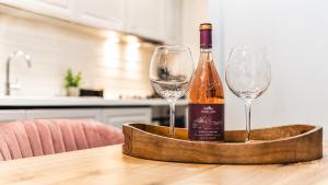 a bottle of wine and two wine glasses on a table at Briana Luxury Panoramic View in Cluj-Napoca