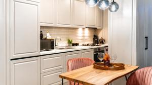 a kitchen with a wooden table with wine glasses on it at Briana Luxury Panoramic View in Cluj-Napoca