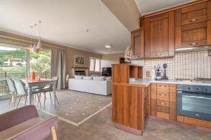 a kitchen with wooden cabinets and a living room at Paradise Sea View Apartments in Lygia