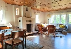 a living room with a table and chairs and a fireplace at Solkullen i Kalvshult in Hallaryd