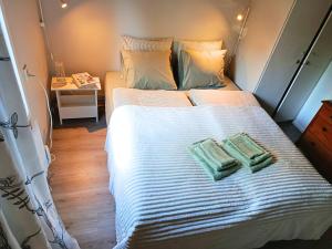 a bedroom with a bed with two green towels on it at Solkullen i Kalvshult in Hallaryd