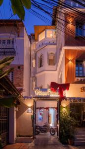 a white building with a sign that reads a restaurant at Chạm's Hotel & Homestay in Ho Chi Minh City