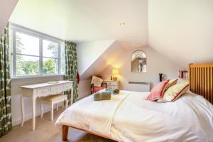 a bedroom with a bed and a desk and a window at 2 Bed in Beaminster oc-63136 in Stoke Abbott