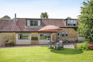 a brick house with an umbrella in the yard at 2 Bed in Beaminster oc-63136 in Stoke Abbott