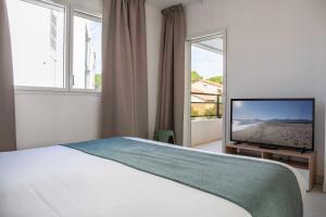 a bedroom with a bed and a flat screen tv at Résidence du Lido in Argelès-sur-Mer