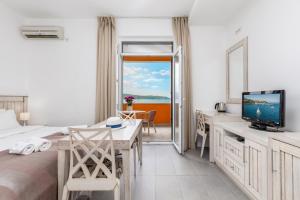 a bedroom with a bed and a desk with a television at Apartments Grifone Lux in Herceg-Novi