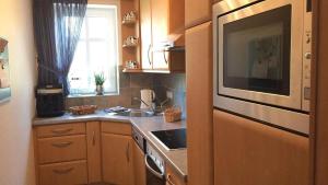 a small kitchen with a sink and a microwave at Residenz Seelust in Langeoog