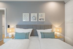 a bedroom with a large white bed with two lamps at Nordseebude Deichtraum in Sankt Peter-Ording