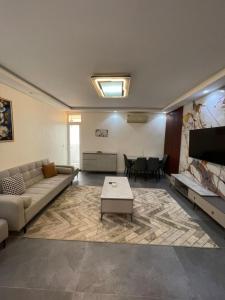 a large living room with a couch and a tv at Résidence You Royal in Dakar