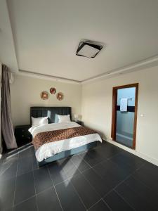 a bedroom with a large bed and a window at Résidence You Royal in Dakar