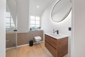 a bathroom with a sink and a toilet and a mirror at Nordseebude Deichtraum in Sankt Peter-Ording