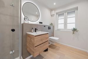 a bathroom with a sink and a toilet and a mirror at Nordseebude Kleine Auszeit in Sankt Peter-Ording +25 photos