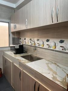 a kitchen with a counter with bowls and plates on the shelf at Résidence You Royal in Dakar