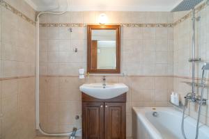 a bathroom with a sink and a mirror and a tub at Paradise Sea View Apartments in Lygia +23 photos