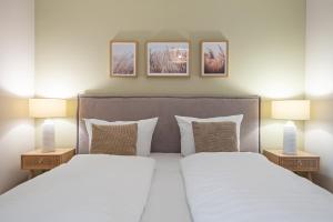 a bedroom with a large bed with two lamps at Nordseebude Kleine Auszeit in Sankt Peter-Ording