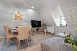 a living room with a table and a television at Nordseebude Küstenglück in Sankt Peter-Ording