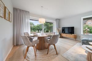 a dining room with a table and chairs and a tv at Nordseebude Strandnest in Sankt Peter-Ording