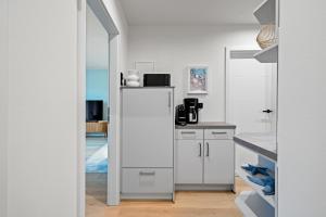 a kitchen with white cabinets and a mirror at Nordseebude Strandnest in Sankt Peter-Ording +18 photos
