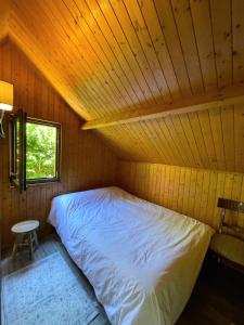 a bed in a room with a wooden ceiling at Kat in Cabourg