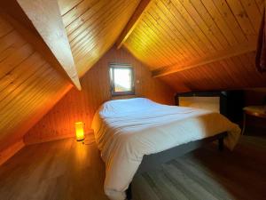 a bed in a wooden room with a window at Kat in Cabourg