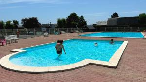 a young child is standing in a swimming pool at Kat in Cabourg