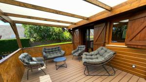 a wooden deck with chairs and a table on it at Kat in Cabourg