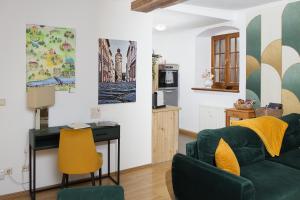 a living room with a green couch and a desk at FeWo Zeitreise I - zauberhafte Altstadtmomente erleben in Görlitz