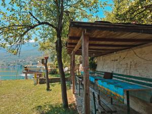 a group of benches sitting under a wooden shelter at Camping 999 Jablaničko jezero in Železnička Stanica Ostrožac