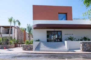 a facade of a building with stairs and palm trees at ARATO by E-GEO, Adults Only in Kos