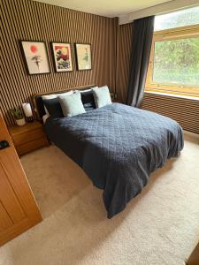 a bedroom with a bed with a blue comforter and a window at Ravelston in Edinburgh